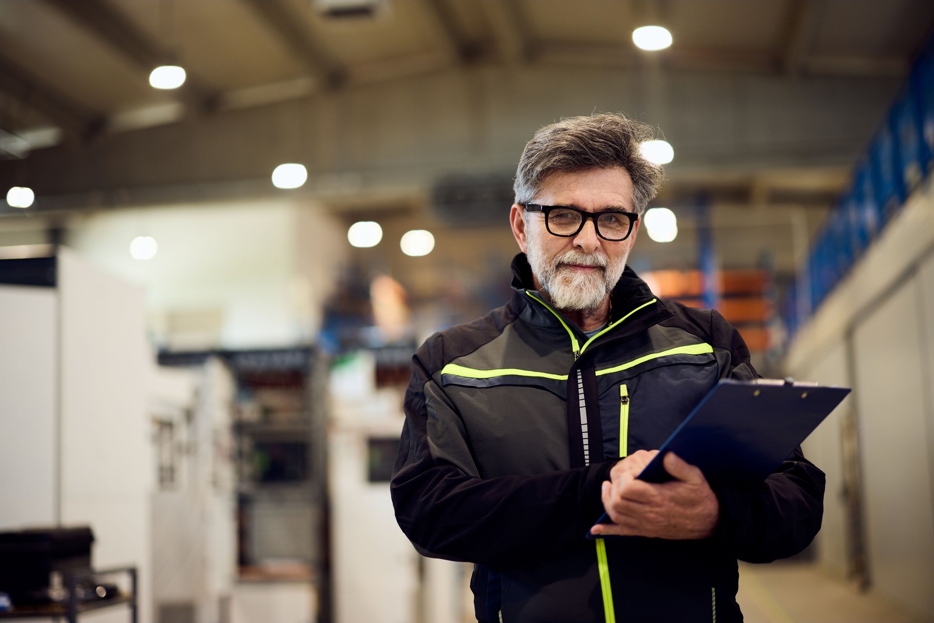 Confident Engineer Holding Clipboard in Industrial Factory Setting