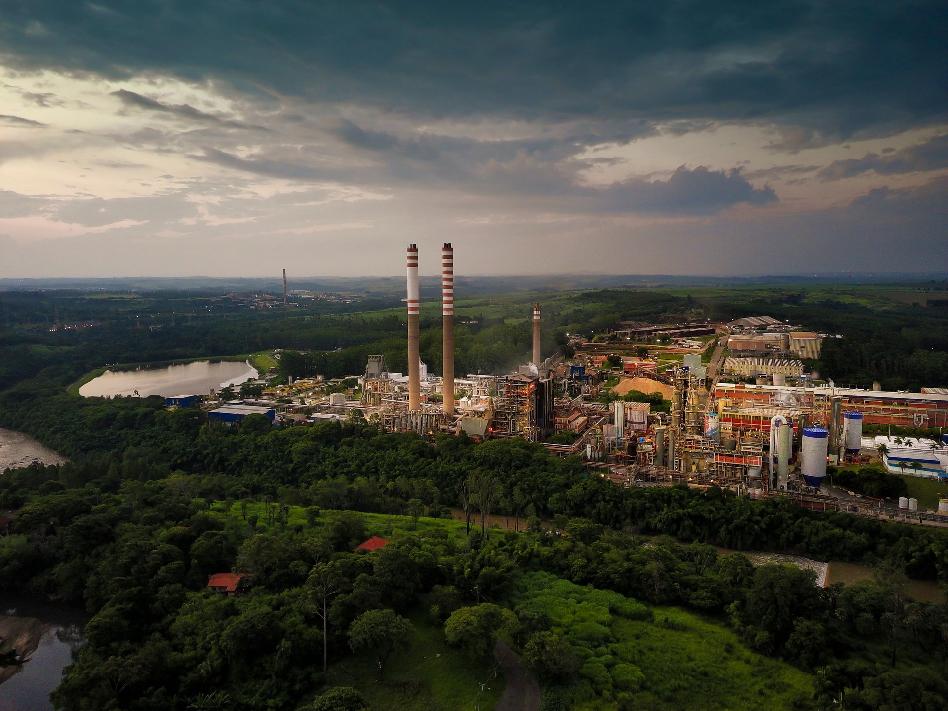 Industrial Landscape with Forest and Chimneys at Sunset